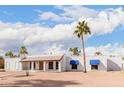 Charming single-story home boasts desert landscaping, light stucco, covered porch, and front awning at 8476 E Wethersfield Rd, Scottsdale, AZ 85260