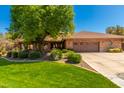 Inviting single-story brick home featuring a well-manicured lawn and a spacious driveway at 8649 S Willow Dr, Tempe, AZ 85284