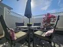 Cozy patio featuring comfortable seating around a metal table with a decorative sun umbrella and flowering plants at 8700 E University Dr # 1947, Mesa, AZ 85207