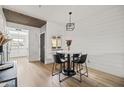 Bright dining area features a marble table, black chairs, a modern light fixture, and a shiplap accent wall at 9450 E Becker Ln # 2019, Scottsdale, AZ 85260