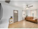 Bright living room featuring a leather sofa, wood floors, and a contemporary ceiling fan at 1622 N 17Th Ave, Phoenix, AZ 85007