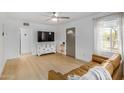 Spacious living room with ample natural light, wood floors, and a modern entertainment center at 1622 N 17Th Ave, Phoenix, AZ 85007