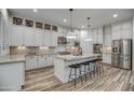 Bright, modern kitchen boasts a large island with seating, white cabinets, and stainless steel appliances at 2027 W Calle De Las Estrella --, Phoenix, AZ 85085