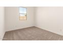 A bright bedroom with neutral carpet, fresh white walls, and a window offering ample natural light at 21960 E Saddle Ct, Queen Creek, AZ 85142