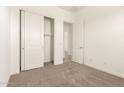 Bright bedroom featuring a closet with sliding doors and neutral-toned carpet flooring at 21960 E Saddle Ct, Queen Creek, AZ 85142
