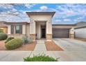Inviting home featuring a two-car garage, neutral color palette, and low maintenance desert landscaping at 22651 E Via Del Verde --, Queen Creek, AZ 85142