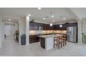 Spacious eat-in kitchen with granite countertops, dark wood cabinets, stainless steel appliances, and center island at 22651 E Via Del Verde --, Queen Creek, AZ 85142