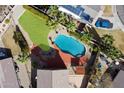 A stunning aerial view showcases a sparkling pool, lush lawn, and solar panels on the home's roof at 23225 N 23Rd Pl, Phoenix, AZ 85024