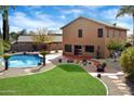 Back exterior view of a home with a covered patio, swimming pool, and desert landscaping at 23225 N 23Rd Pl, Phoenix, AZ 85024