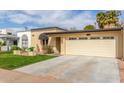 Inviting single-story house featuring a two-car garage, stylish awning, and well-kept lawn at 2510 E Crittenden Ln, Phoenix, AZ 85016