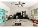 Cozy living room with neutral carpet, ceiling fan, and comfortable seating at 25913 W Cat Balue Dr, Buckeye, AZ 85396