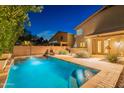 A private backyard pool is surrounded by a stone patio and desert landscaping for the ultimate retreat at 26711 N 21St Dr, Phoenix, AZ 85085