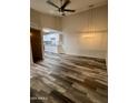 Living room with wood-look floors, modern lighting, and an open view of the renovated kitchen at 3646 N 67Th Ave # 83, Phoenix, AZ 85033