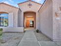 Inviting entrance of a single-story home with desert landscaping leading to a charming wooden front door at 4215 W Reddie Loop, Phoenix, AZ 85083