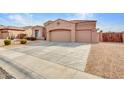 Single-story home with a three-car garage and extended driveway, showcasing low-maintenance desert landscaping at 4215 W Reddie Loop, Phoenix, AZ 85083