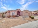 Inviting single-story home with a desert landscape, cacti, and a spacious three-car garage at 4215 W Reddie Loop, Phoenix, AZ 85083