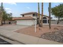 A two-story residence featuring a three-car garage and desert landscaping with cacti at 5246 E Enrose St, Mesa, AZ 85205