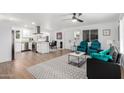 Bright open-concept space featuring hardwood floors, a marble coffee table, and an open kitchen concept at 5725 E Colby St, Mesa, AZ 85205