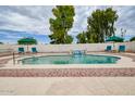 Inviting pool with a waterfall feature and ample seating for relaxation at 6020 E Shea Blvd, Scottsdale, AZ 85254