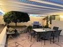 Cozy outdoor patio with dining table, chairs, grill, and decorative greenery at 6614 E Portia St, Mesa, AZ 85215