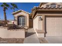 Charming two-story home featuring a neutral exterior, desert landscaping, and a two-car garage at 7452 W Los Gatos Dr, Glendale, AZ 85310