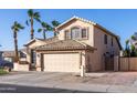 Charming two-story home featuring a neutral exterior, desert landscaping, and a two-car garage at 7452 W Los Gatos Dr, Glendale, AZ 85310