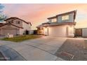 View of a two-story house with a tile roof, two-car garage, driveway, and landscaping at 7953 W Topeka Dr, Glendale, AZ 85308