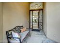 Inviting entryway with a decorative glass door, a comfortable bench, and a view into the living space at 11919 E Del Timbre Dr, Scottsdale, AZ 85259