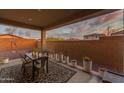 A covered patio features a metal table and chairs, planters, and a patterned rug at 13341 W Yearling Rd, Peoria, AZ 85383