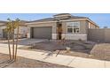 Attractive single-story home with a neutral-colored exterior, a two-car garage, and simple landscaping at 15397 W Hackamore Dr, Surprise, AZ 85387