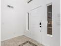 Bright entryway featuring neutral tile flooring, white walls, and a secure white front door at 16161 W Monte Cristo Ave, Surprise, AZ 85374