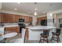 Bright kitchen featuring tile backsplash, a large island, stainless steel appliances, and ample cabinet space at 20392 W Brittlewood Ave, Buckeye, AZ 85396