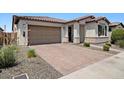 Paver driveway leads to a two-car garage with lovely landscaping at 20886 E Sparrow Dr, Queen Creek, AZ 85142