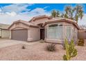 Tan single-story home showcasing desert landscaping featuring cacti, shrubbery, and a neutral-toned rock ground cover at 2704 E Anderson Dr, Phoenix, AZ 85032