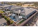 An aerial view of a private backyard with a pool, spa, covered patio, solar panels, and lush landscaping at 30331 N 115Th Ln, Peoria, AZ 85383