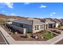 Charming single-story house showcasing desert landscaping, a stone entryway, and a brick-paved driveway at 30331 N 115Th Ln, Peoria, AZ 85383