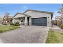 Attractive single-story home with a gray garage door and a spacious brick driveway at 3504 E Boot Track Trl, Gilbert, AZ 85296