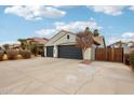 Three car garage and long driveway in desert landscaping with privacy gate at 3793 S Seton Ave, Gilbert, AZ 85297