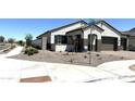 Beautiful single-story home with a three car garage, manicured yard, and street signage at 43527 N Wollemi St, Queen Creek, AZ 85140