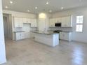 Bright, open-concept kitchen features white cabinets, a center island and modern appliances at 43527 N Wollemi St, Queen Creek, AZ 85140