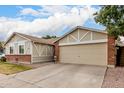 View of the house with its neutral color, brick accents, and wide two-car garage at 6335 E Brown Rd # 1081, Mesa, AZ 85205