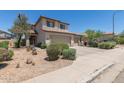 Two-story tan home with a three car garage and desert landscaping at 6350 W Hess St, Phoenix, AZ 85043