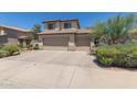 Two-story tan home with a three car garage and desert landscaping at 6350 W Hess St, Phoenix, AZ 85043