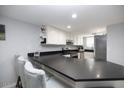 Kitchen featuring a dark countertop with seating and white cabinets at 6454 E University Dr # 5, Mesa, AZ 85205