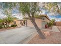 Charming single-story home featuring a long driveway leading to a two-car garage at 7322 S Sunset Way, Buckeye, AZ 85326