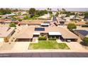 An aerial view shows a single-story home with carport and lawn, surrounded by a desert neighborhood at 10816 W Venturi Dr, Sun City, AZ 85351