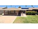 Single story home showcasing a covered carport, solar panels, landscaped front yard, and charming desert foliage at 10816 W Venturi Dr, Sun City, AZ 85351