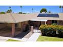 Single story home highlighting a covered carport, solar panels, walkway to gated entry and mature landscaping at 10816 W Venturi Dr, Sun City, AZ 85351