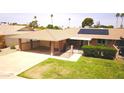 Aerial view of a single-story home featuring a carport, lawn, and gated patio with solar panels at 10816 W Venturi Dr, Sun City, AZ 85351