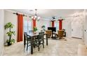 Bright living area with tile floors, open dining space, large windows, and stylish furniture arrangement at 10825 W El Cortez Pl, Peoria, AZ 85383